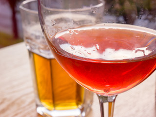 Friendly meeting with a glass of wine and a glass of beer in the city cafe.