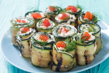 Zucchini rolls with cream cheese , tomatoes and dill
