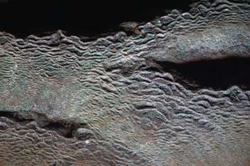 Rough stone surface detail of ancient limestone deposit in dark cave in rural Vietnam