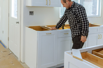 A carpenter is building a drawers garbage bin in the kitchen