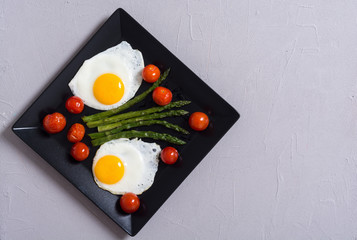 Healthy breakfast with eggs , asparagus and tomatoes
