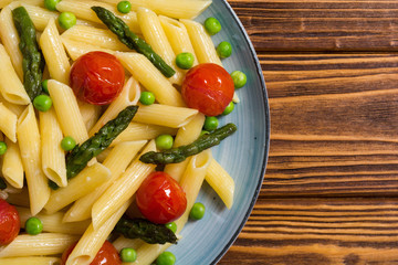 Penne pasta salad with asparagus , tomatoes and peas