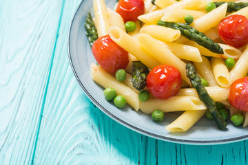 Penne pasta salad with asparagus , tomatoes and peas