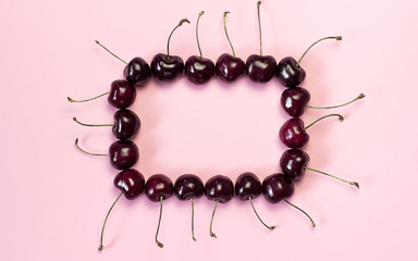  frame of sweet cherry berries on a pink background with a space for the text