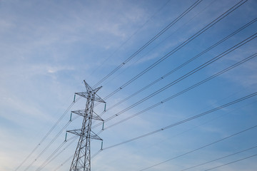 High voltage post tower with blue sky before sunset