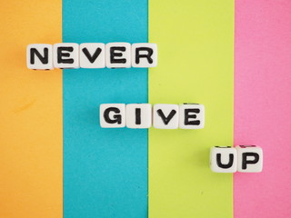カラフルな背景にネバーギブアップという単語