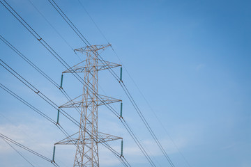 High voltage post tower with blue sky before sunset