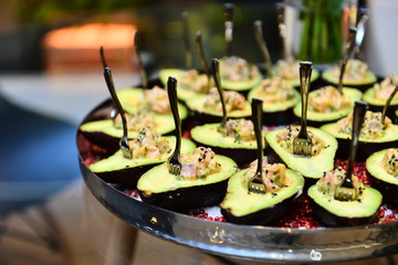 avocado with shrimp and chia on a silver platter, halved avocado
