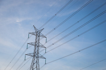 High voltage post tower with blue sky before sunset