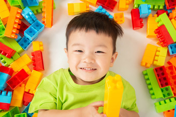 Little boy toddler playing plastic brick block colorful with happy