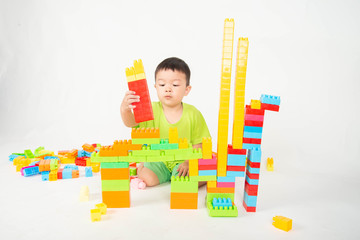 Little boy toddler playing plastic brick block colorful with happy