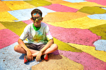 boy after the Crazy Color Run marathon sitting on a colorful map. copy space for your text