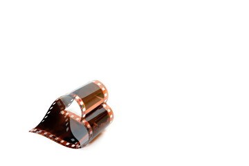 Film folded in the shape of a heart in the corner on a white background. Isolated