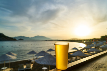 Fototapeta premium Cold tasty beer and view of the beach