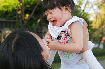 Obraz premium Close-up mother carrying her little girl and crying in park