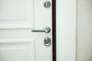 Door handle in white door with silver locks