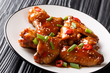 Chinese baked chicken wings with teriyaki sauce close-up on a plate. horizontal