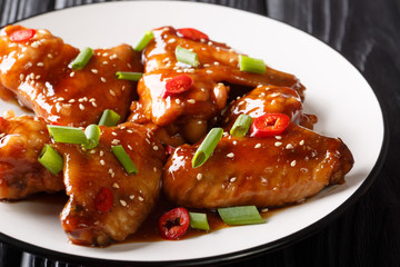 Baked spicy chicken wings with teriyaki sauce close-up on a plate. horizontal