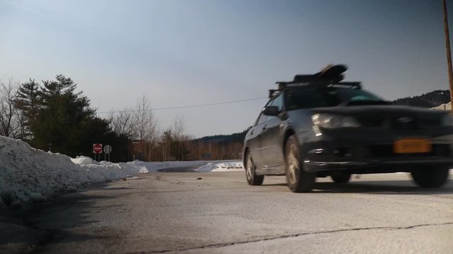 Black car speeding up an on ramp of highway.