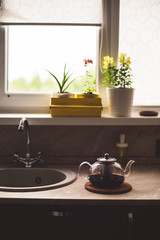 kettle stands on the table in the kitchen summer home comfort flowers