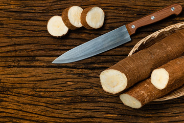 Fototapeta na wymiar Raw Cassava. Pieces of Manihot esculenta. Wooden background old