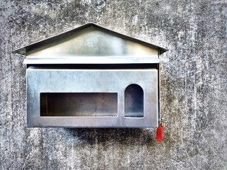 Steel mailbox house shape on old cement wall, Mailbox for envelope.