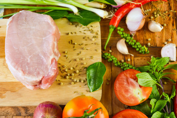 Fresh meat pig and spices are placed on the cutting board and wooden floors for cooking today.