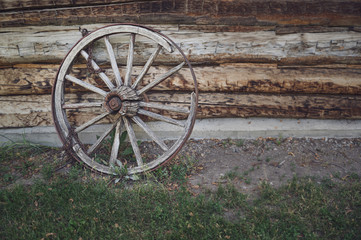 Obraz premium old wooden wagon wheel with a rusty chain wrapping around one of the spokes