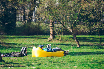 book reading concept. man in city park on inflatable mattress