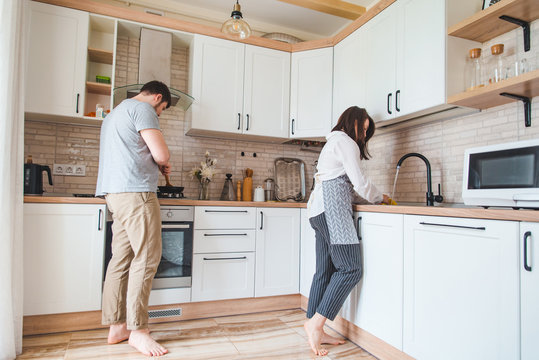 Couple Cooking On Kitchen Washing Dishes