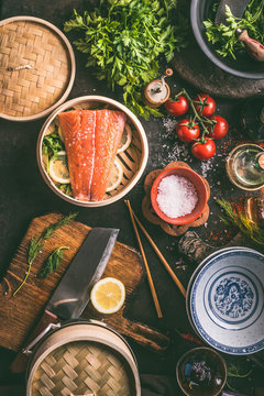 Authentic Asian Food Cooking Preparation With Salmon,seasoning, Spices, Bowls And Chopsticks On Dark Kitchen Table, Top View. Various Ingredients, Utensils And Tools On Kitchen Table.  Asian Cuisine