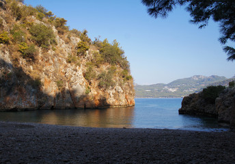 Fototapeta premium Seashore in Turkey. Summer beach with stones in the bay of the ocean.