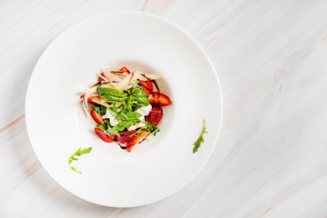 healthy salad with strawberries on the marble background
