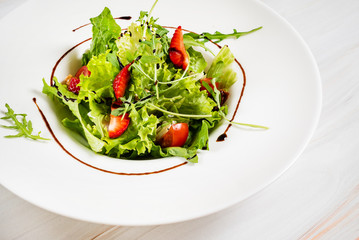 healthy salad with strawberriesa and arugula