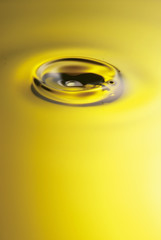 Golden yellow oil dropping and rippling over the abstract background	