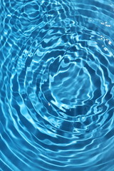 Blue and bright water surface with sun refection in swimming pool for background
