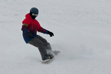 Fototapeta na wymiar snowboarder in ski equipment rides from the mountain