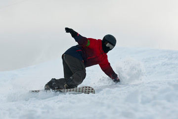 snowboarder riding over the slope prepared by snowcat.