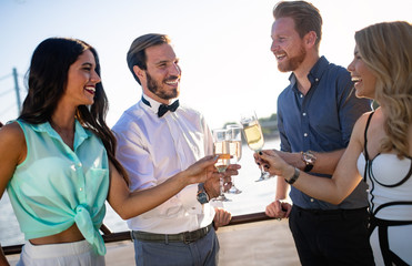 Group of happy friends partying and toasting drinks