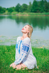 Pretty woman in traditional embroidered shirt with blue elements. Slavic culture 