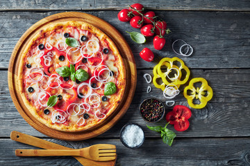 Fototapeta na wymiar pizza with tomatoes, cheese, onions, ham, olives