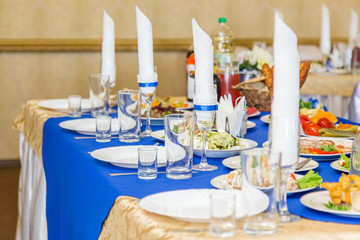Served banquet table with plates, glasses and dishes