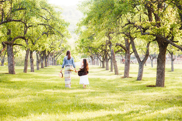 Fototapeta premium Two sisters in boho outfits are walking around the village. Beautiful, summer landscape. Country Holiday...