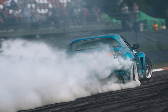 Sport car in motion with a lot of smoke. Race car make a turn at high speed