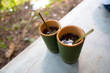 two clay cups on table. forest on background