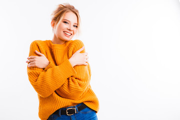 Beautiful girl in a yellow sweater gesticulates with her hands.