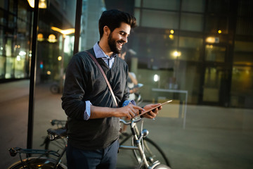 Portrait of young businessman holding tablet outdoor
