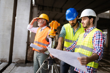Engineer, foreman and worker discussing in building construction site