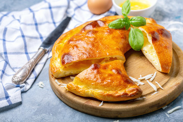 Cut closed pie with cheese and egg (khachapuri).
