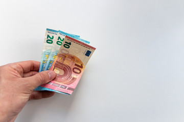 Männerhand hält Geldschein zur Bezahlung mit Bargeld oder als Prämie / Provision bereit